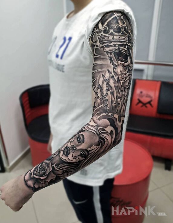 Tattoo Martwy król in flowers motif and realistic style on the upper arm
