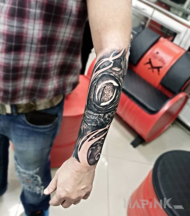 Tattoo Gadzie oko in dragons motif and realistic style on the forearm