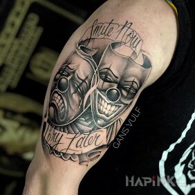 Tattoo Theatrical masks on the upper arm motif: lettering style: graphic / illustrative