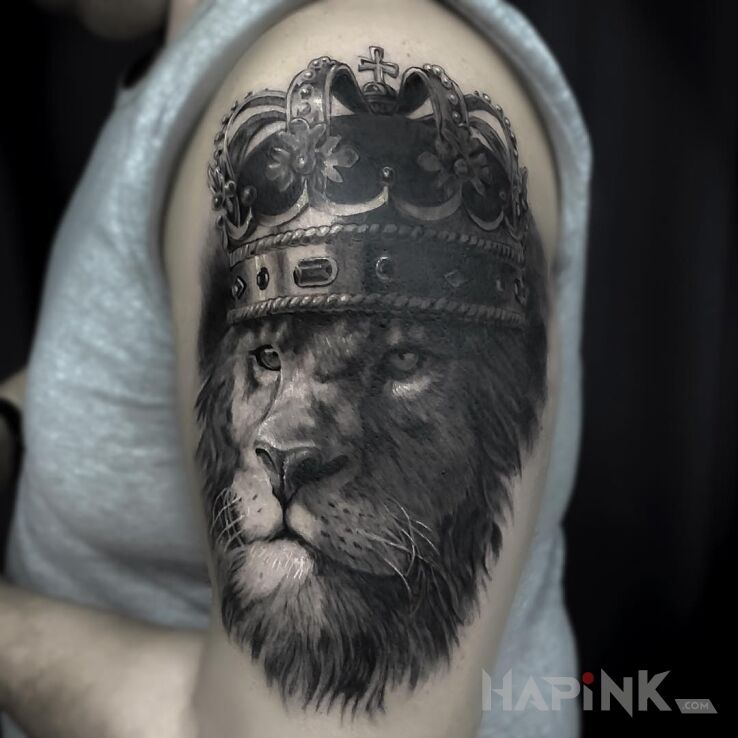 Tattoo Król lew in black and gray motif and realistic style on the upper arm