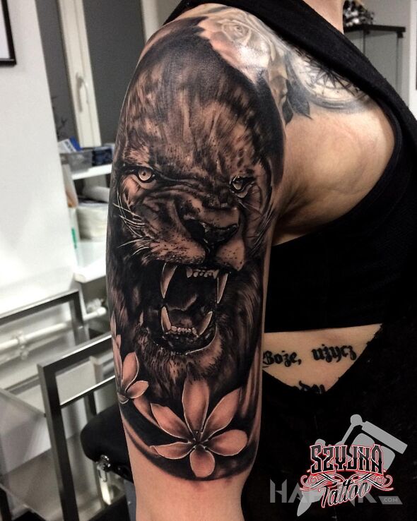 Tattoo Lion King ? in flowers motif and realistic style on the upper arm