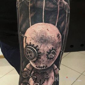 Tattoo Doll on the forearm motif: black and gray style: realistic