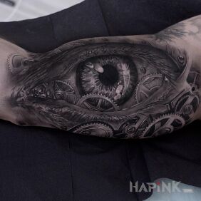 Tattoo Eye in the cogs on the upper arm motif: other style: realistic
