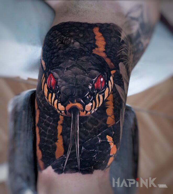 Tattoo Czerwone oczy węża in colorful motif and realistic style on the upper arm