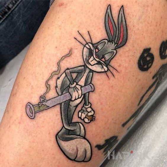 Tattoo Weed Bucks in characters motif and cartoon / comic book style on the forearm