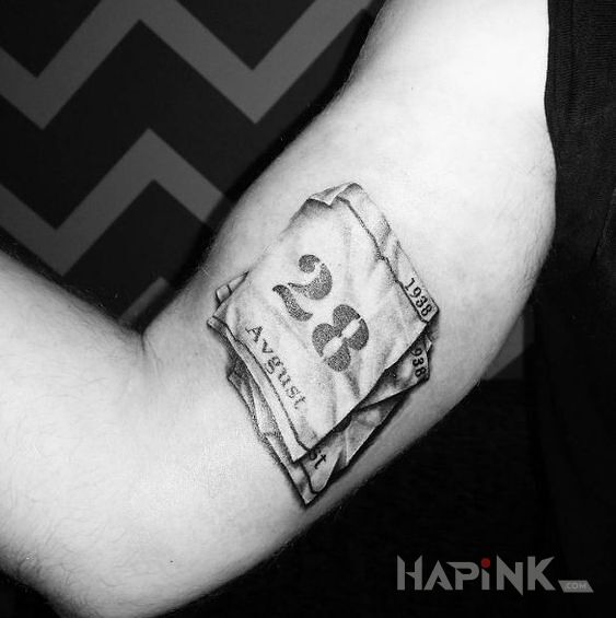 Tattoo 28 Sierpnia in black and gray motif and realistic style on the upper arm