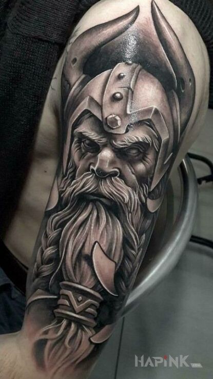 Tattoo Potężny wiking in faces motif and realistic style on the upper arm