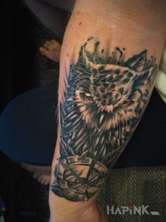 Tattoo Sowa in black and gray motif and realistic style on the forearm