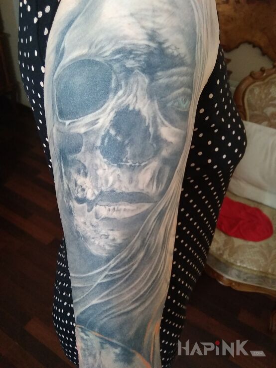 Tattoo Inni in skulls motif and realistic style on the upper arm