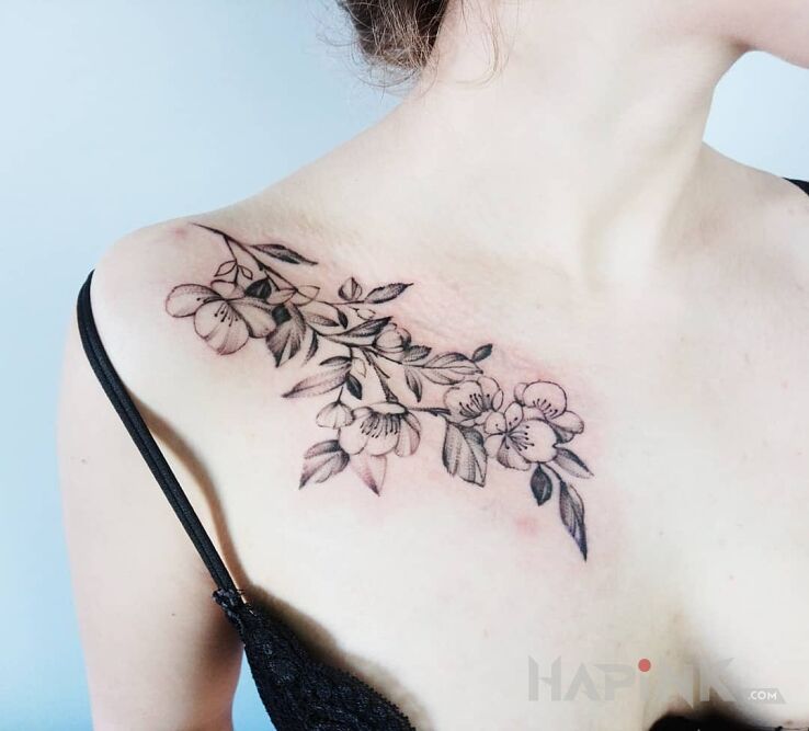 Tattoo Gałązka wiśni in flowers motif and realistic style on the collarbone