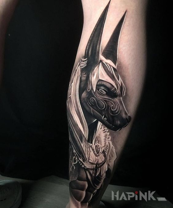 Tattoo Anubis in black and gray motif and realistic style on the calf