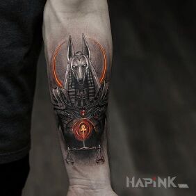 Tattoo Anubis with weight on the forearm motif: black and gray style: graphic / illustrative