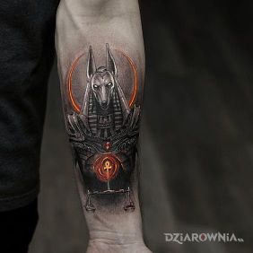 Tatuaż Anubis z wagą na przedramieniu motyw: czarno-szare styl: graficzne / ilustracyjne