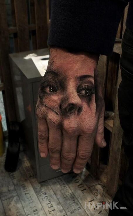 Tattoo Portret in faces motif on the hand