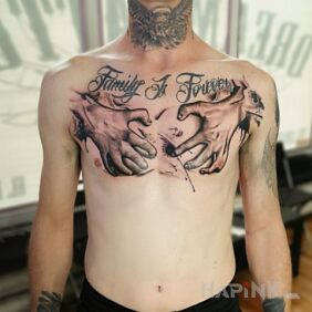 Tattoo Hands on chest on the chest motif: lettering style: realistic