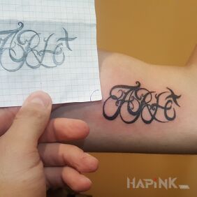 Tattoo Arh+ on the upper arm motif: lettering style: minimalistic