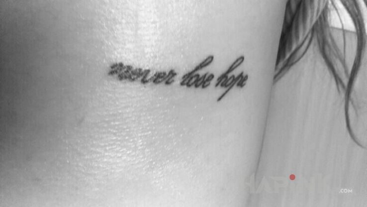 Tattoo Never lose hope in lettering motif on the ribs