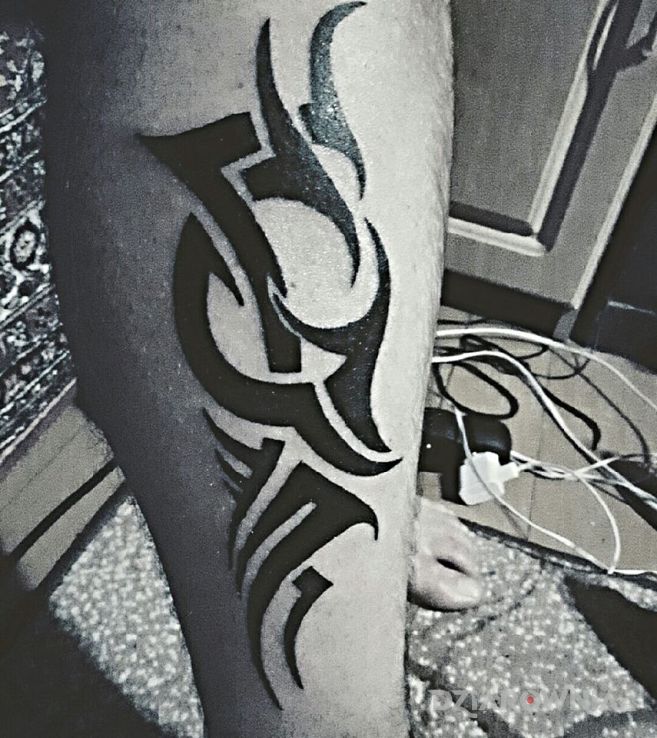Tatuaż kolejny tribal w stylu tribale na łydce