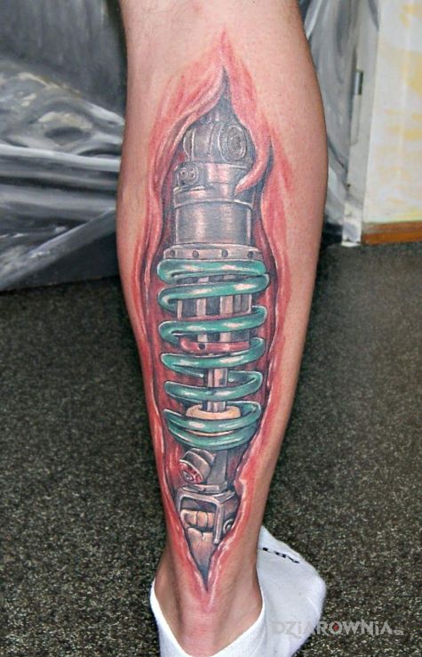 Tatuaż tatoo w motywie kolorowe i stylu biomechanika na łydce
