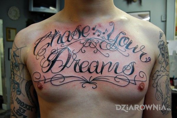 Tatuaż chase your dreams w motywie napisy na klatce