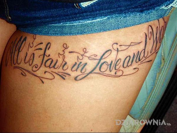 Tatuaż all is fair in love and war w motywie napisy na nodze