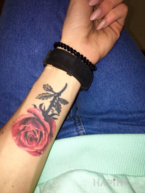 Tattoo Róża in colorful motif and realistic style on the forearm