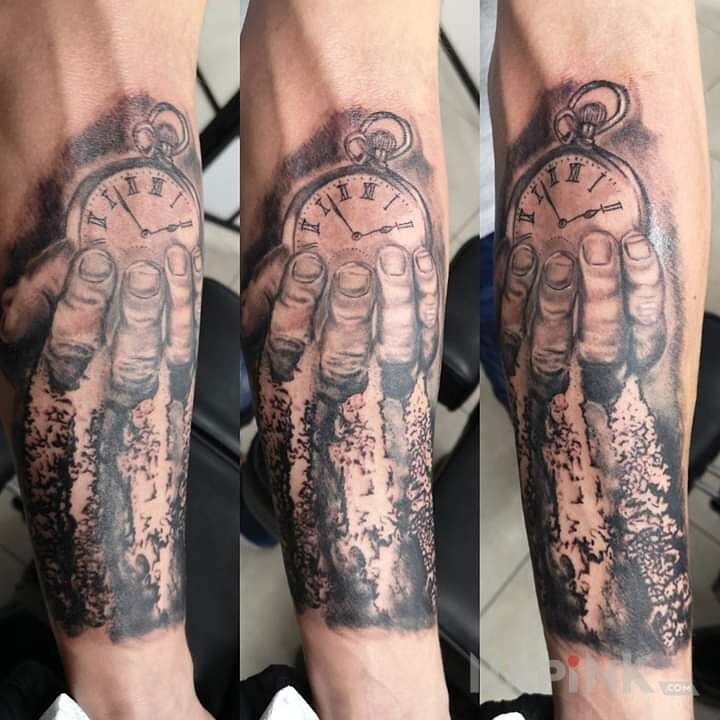 Tattoo ,, Tik tak Tik tak '' in black and gray motif and realistic style on the forearm