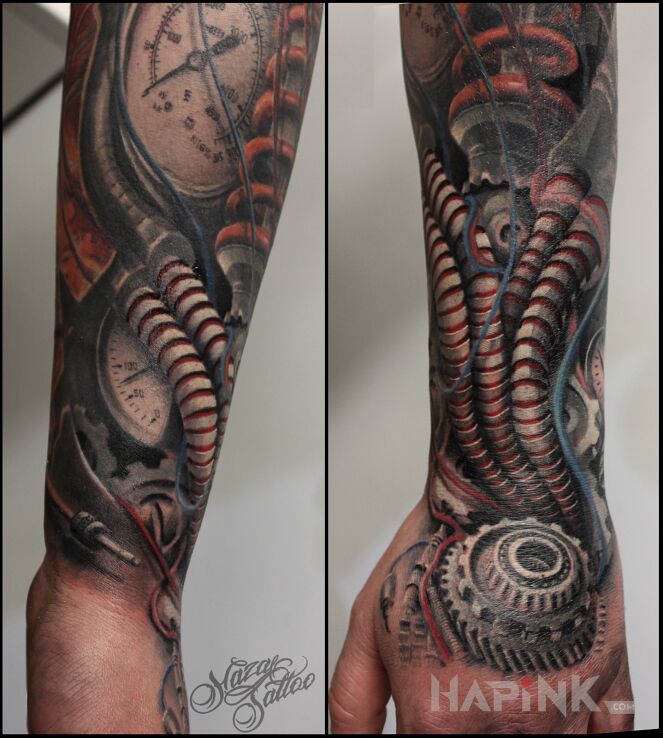 Tattoo Biomechhanika in colorful motif and biomechanics style on the forearm