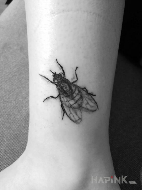 Tattoo Muszka in black and gray motif and realistic style on the leg