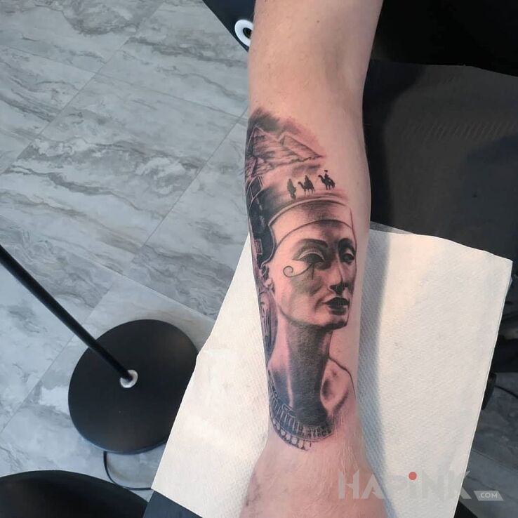 Tattoo Nefretete in faces motif and realistic style on the forearm