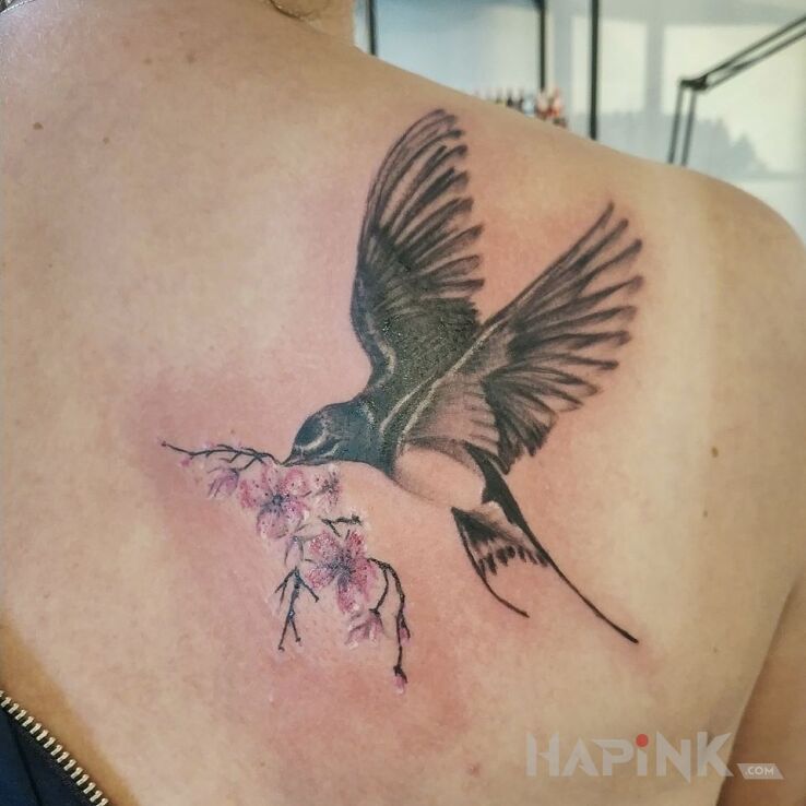 Tattoo Jaskółka in colorful motif and realistic style on the back