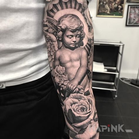 Tattoo Boski cherubin in flowers motif and realistic style on the forearm