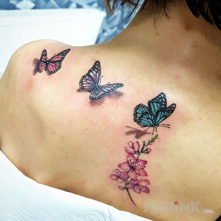 Tattoo Motylove in flowers motif and realistic style on the back