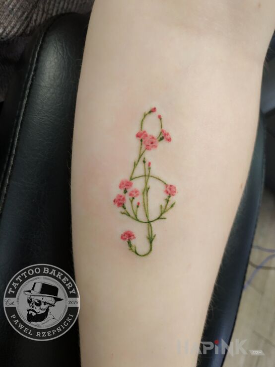 Tattoo Klucz wiolinowy in colorful motif and graphic / illustrative style on the forearm