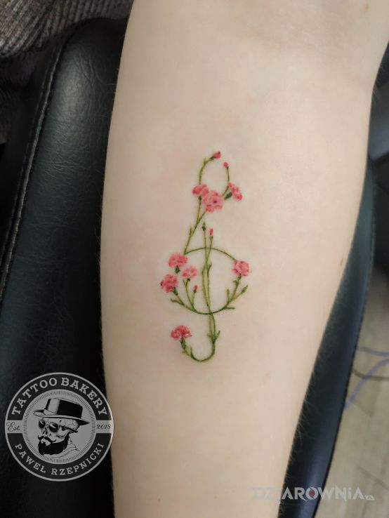 Tatuaż klucz wiolinowy w motywie kwiaty i stylu graficzne / ilustracyjne na przedramieniu