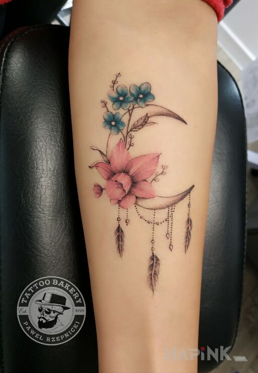 Tattoo Księżyc in flowers motif and graphic / illustrative style on the forearm