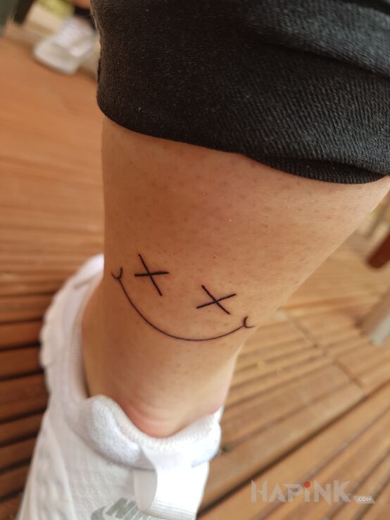 Tattoo Usmiech in other motif and minimalistic style on the leg
