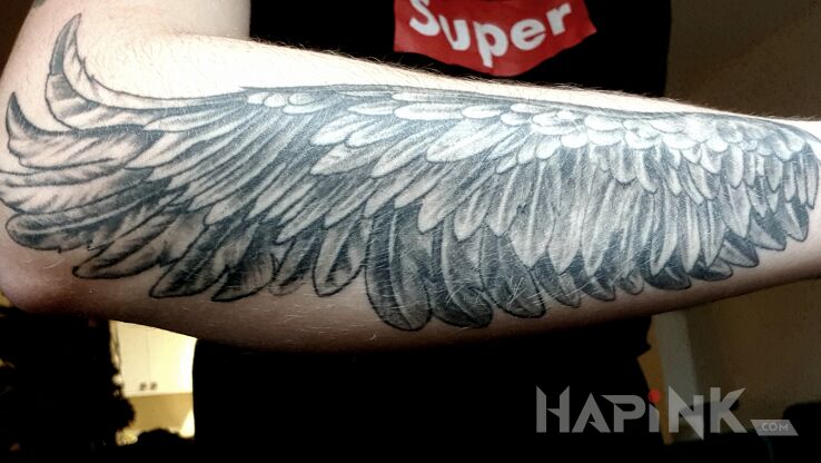 Tattoo Skrzydlo in wings motif and realistic style on the forearm