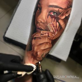Tatuaż Kolorowa twarz z żyletką na przedramieniu motyw: twarze styl: realistyczne