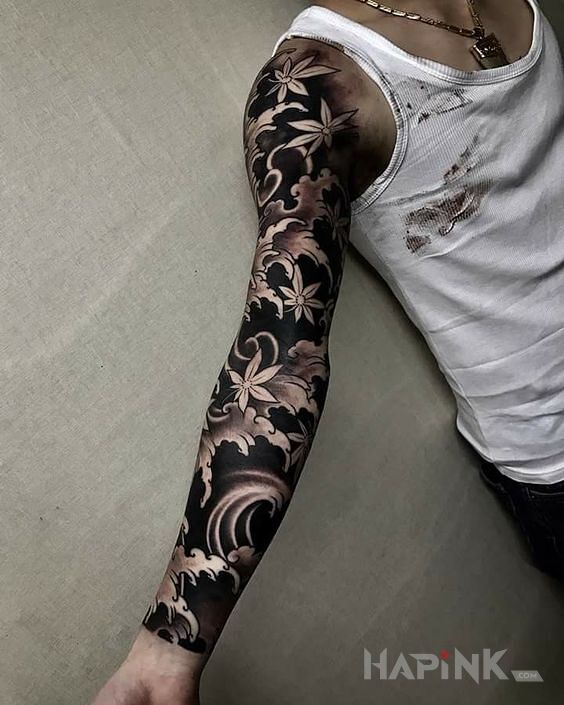 Tattoo Kwiaty wiśni na wietrze in flowers motif and blackwork / blackout style on the upper arm