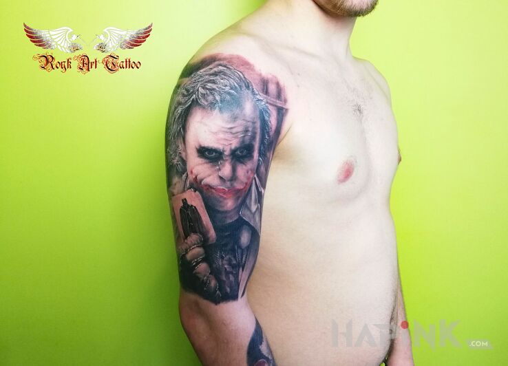 Tattoo Joker in black and gray motif and realistic style on the upper arm