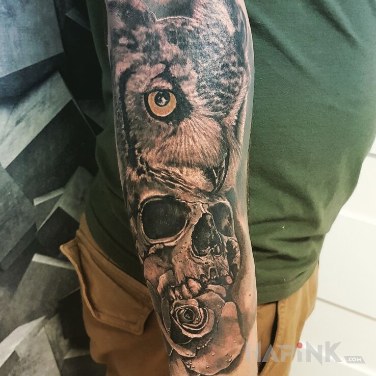 Tattoo Sowa in black and gray motif and realistic style on the forearm