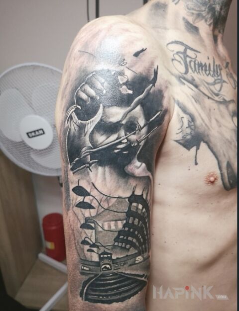 Tattoo Oswiecim in black and gray motif and realistic style on the upper arm