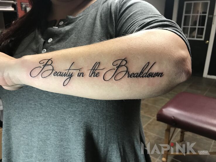 Tattoo Piękno w podziale in lettering motif and calligraphy style on the forearm