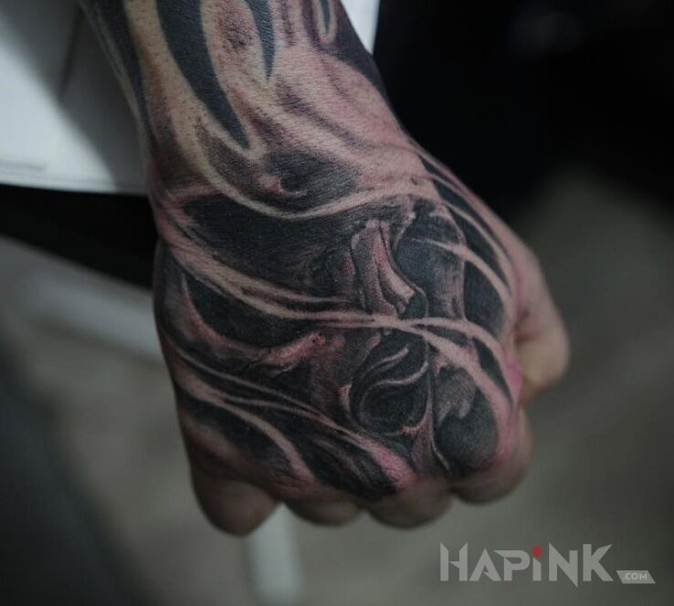 Tattoo Czaszka in skulls motif on the hand
