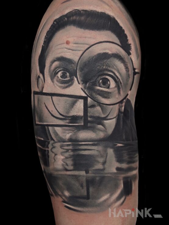 Tattoo Salvador Dali in black and gray motif and realistic style on the upper arm