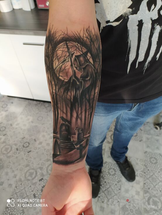 Tattoo Cmentarz in dark motif and realistic style on the forearm