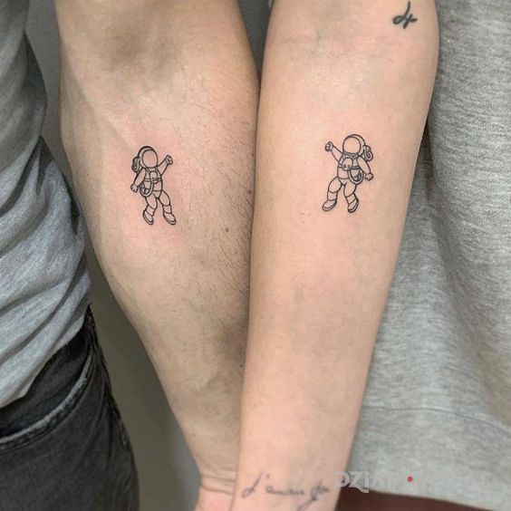 Tatuaż dwoje astronautów w motywie postacie i stylu kontury / linework na przedramieniu
