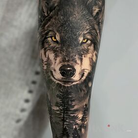 Tattoo A wolf with a forest on the forearm motif: animals style: realistic
