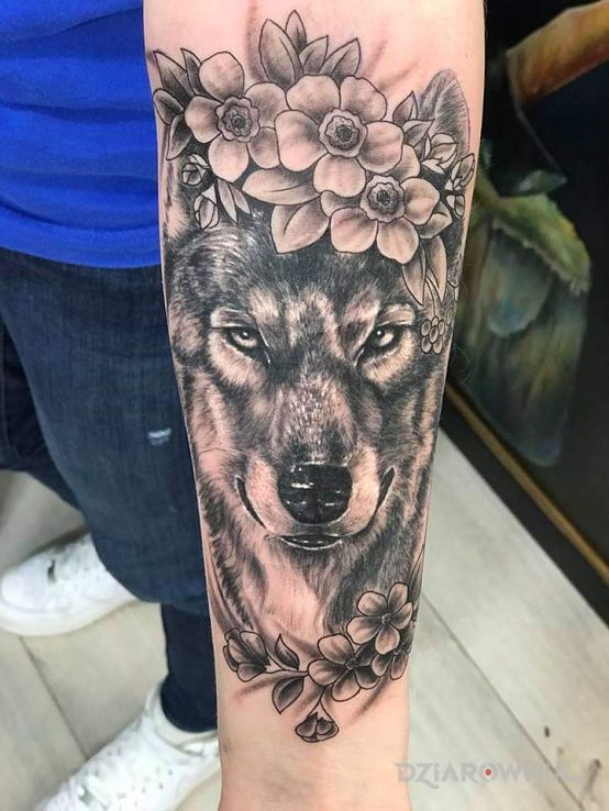 Tatuaż wilk wśród kwiatów w motywie czarno-szare i stylu realistyczne na przedramieniu